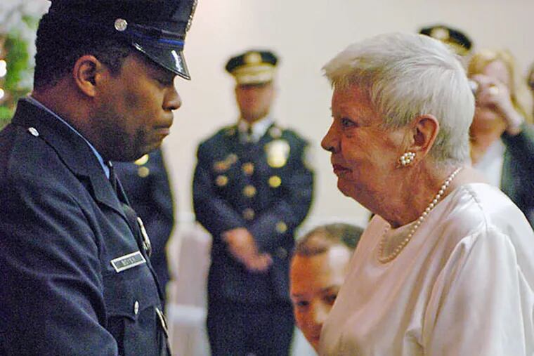 Officer Andre Boyer in 2008 with Rosalyn Harris, sister of Officer Walter Barclay, who was disabled in 1966 and who once wore the same badge number Boyer was later assigned. To honor Barclay, Boyer gave up the number after the officer died in 2007. JESSICA WESTERGOM / File Photograph