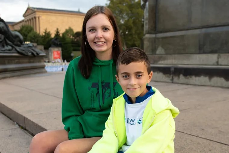 Lily Walker (left) with her cousin Peter Cellucci on the steps of the Washington Monument fountain at Eakins Oval at the 20th annual CHOP Parkway Run & Walk on Sunday in Philadelphia.