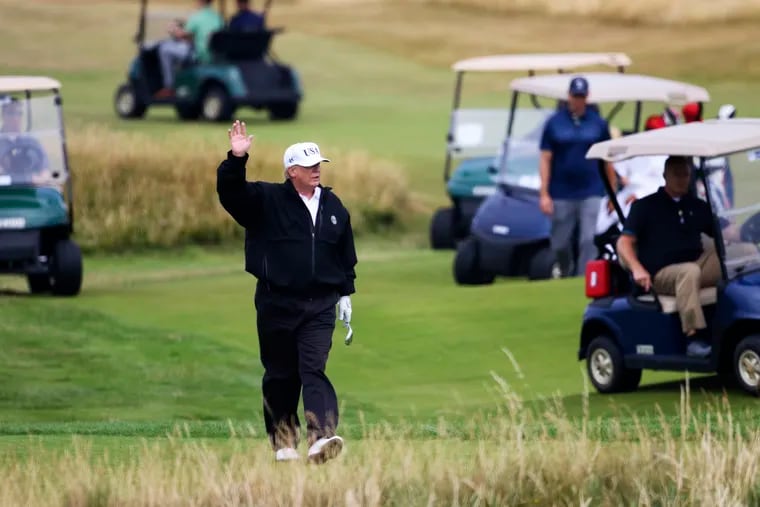 FILE - In this July 14, 2018 file photo, President Donald Trump waves to protesters while playing golf at Turnberry golf club, in Turnberry, Scotland. Trump’s alleged misdeeds on and around the golf course are the subject of a new book by former sports columnist Rick Reilly, called “Commander in Cheat: How Golf Explains Trump.”
