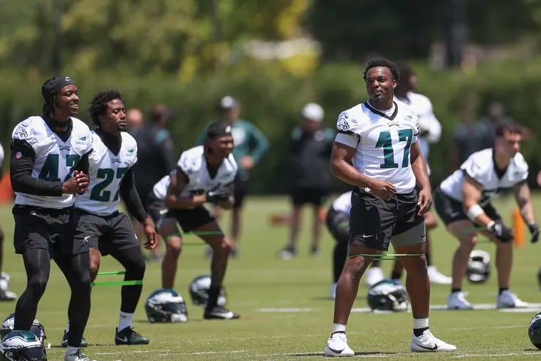 Eagles linebacker Nakobe Dean speaks with teammtes while stretching during OTAs at the NovaCare Complex in Philadelphia on Thursday, June 1, 2023.