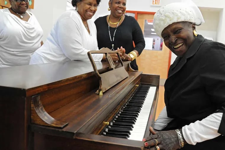 Janie Walker, 79, laughs after playing a song at the NewCourtland LIFE Center in North Philadelphia. A NewCourtland executive rescued the piano from a trash heap and refurbished it.