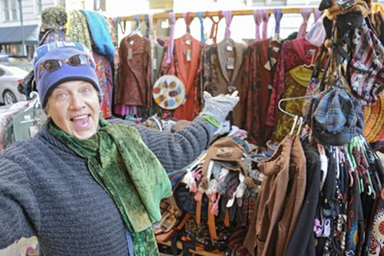 Apparel and accessories dealer Grace Gardner needs her own warm garments to work outside at 18th and Walnut Streets. (Clem Murray / Staff Photographer)