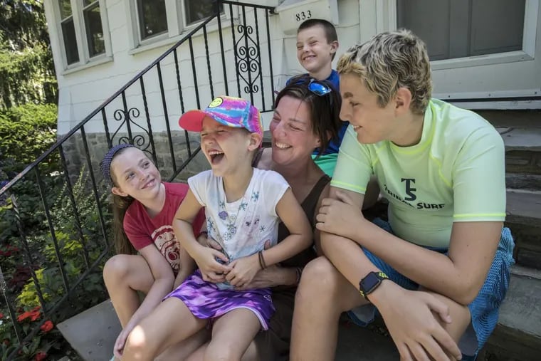 The McGonigle family sits on the front steps of their Havertown home and play a funny 20 questions. From left to right, front row: Maire McGonigle, 10; Aislin McGonigle, 6; Rachel Dougherty McGonigle; and Sam McGonigle, 12. On the top step is Josh McGonigle, 8.  MICHAEL BRYANT / Staff Photographer