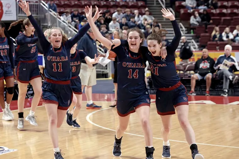 Cardinal O’Hara players including Greta Miller (left) and Carly Coleman (center), and Megan Rullo (right) celebrate their victory after beating Spring-Ford in the PIAA Class 6A girls' basketball championship at the Giant Center in Hershey on March 22.