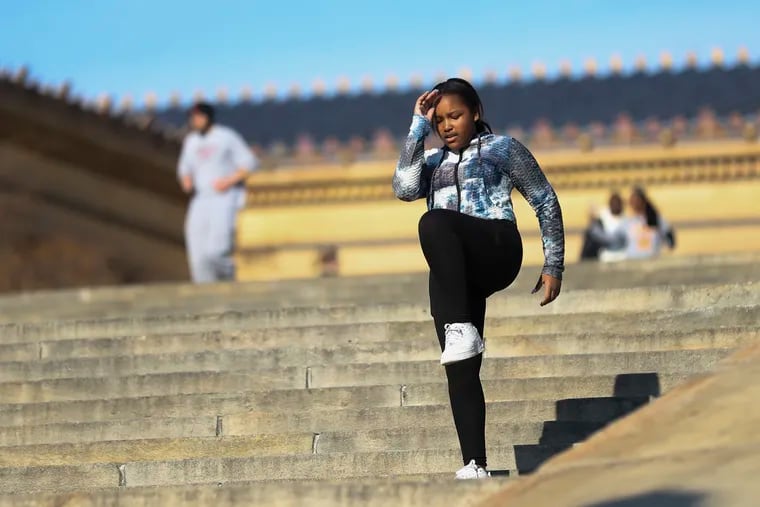 A woman exercises on the steps of the Philadelphia Museum of Art