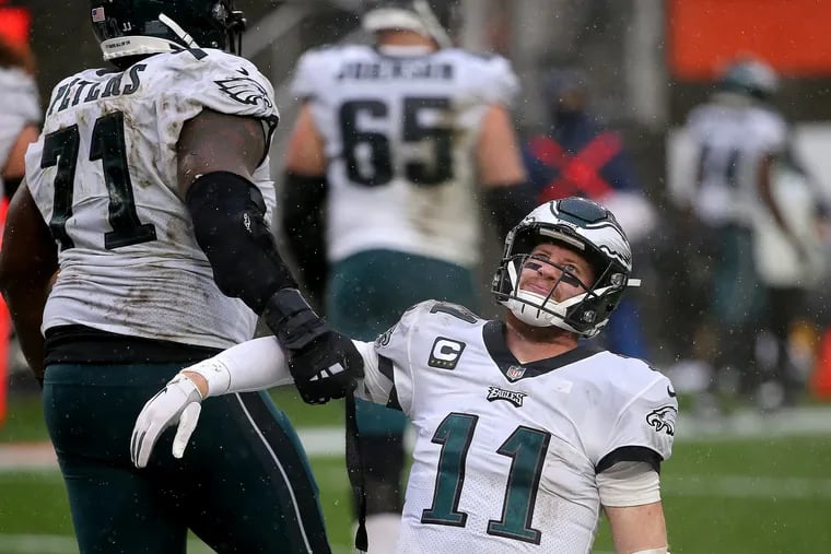 Jason Peters trying to help quarterback Carson Wentz to his feet after Wentz was sacked for a safety last season at Cleveland.