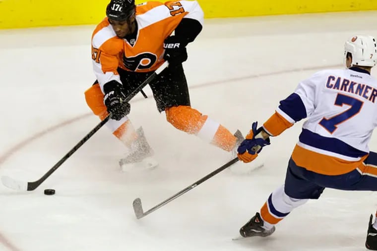 Wayne Simmonds (17) moves the puck past the Islanders' Matt Carkner (7) in the third period of an NHL hockey game, Saturday, Nov. 23, 2013, in Philadelphia. Flyers won 5-2.  (Laurence Kesterson/AP)