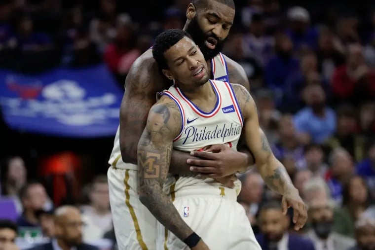 Sixers center Kyle O'Quinn holds up teammate guard Trey Burke from falling after Burke got fouled driving to the basket against the Cleveland Cavaliers on Dec. 7.