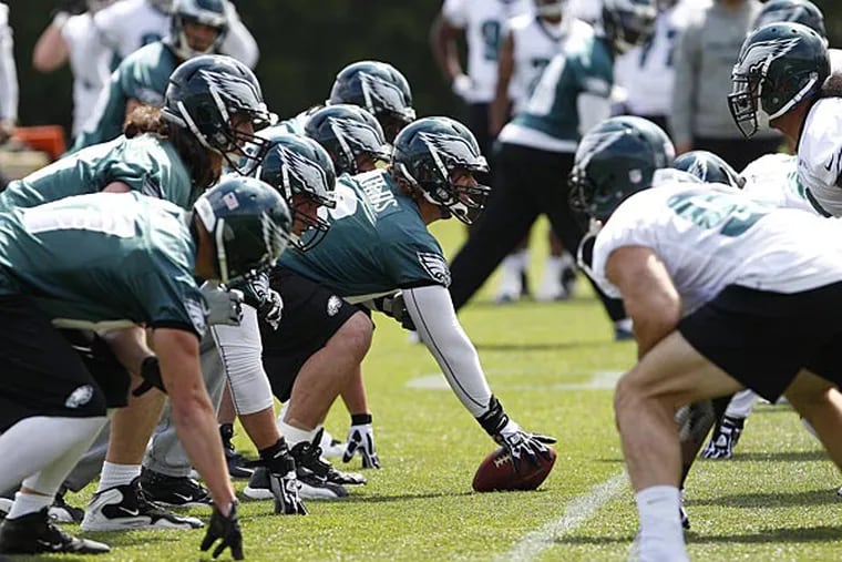 Dallas Reynolds, center, prepares to hike the ball as the Eagles held
organized team activities at the NovaCare Complex in Philadelphia on
May 13, 2013. (David Maialetti/Staff Photographer)