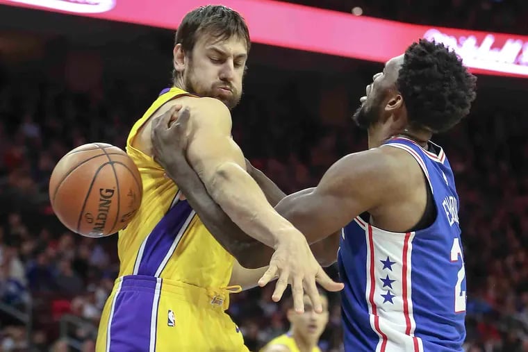 Sixers' Joel Embiid is fouled by Andrew Bogut during a December 2017 game when Bogut was with the Lakers.
