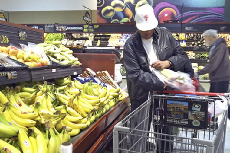 Freddie Dunlap, 68, who lives in Faison Mews, selects bananas at the ShopRite in Brooklawn after arriving via shuttle. (Tom Gralish / Staff Photographer)