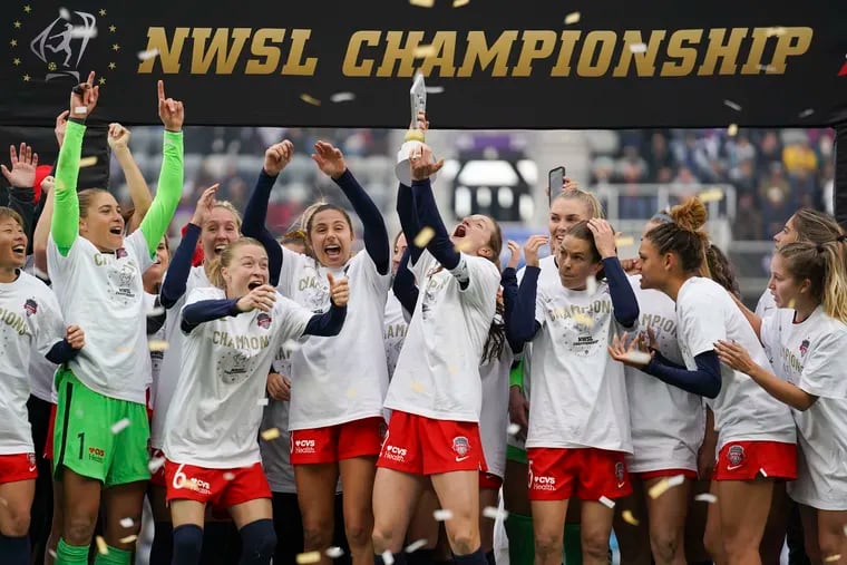 Andi Sullivan (center) lifts the trophy surrounded by teammates after the Washington Spirit won the NWSL championship game.