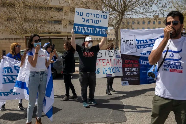 A man holds a sign, center, that reads, "Keeping Israel Jewish and democratic," during a protest by supporters of Prime Minister Benjamin Netanyahu, in front of Israel's Supreme Court, in Jerusalem, on Tuesday.