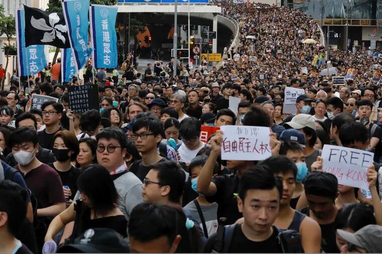 Protesters march in Hong Kong on Sunday, July 7, 2019. Protesters in Hong Kong are taking their message to visitors from mainland China on Sunday in a march to a high-speed rail station that connects to Guangdong city and other mainland destinations. (AP Photo/Vincent Yu)