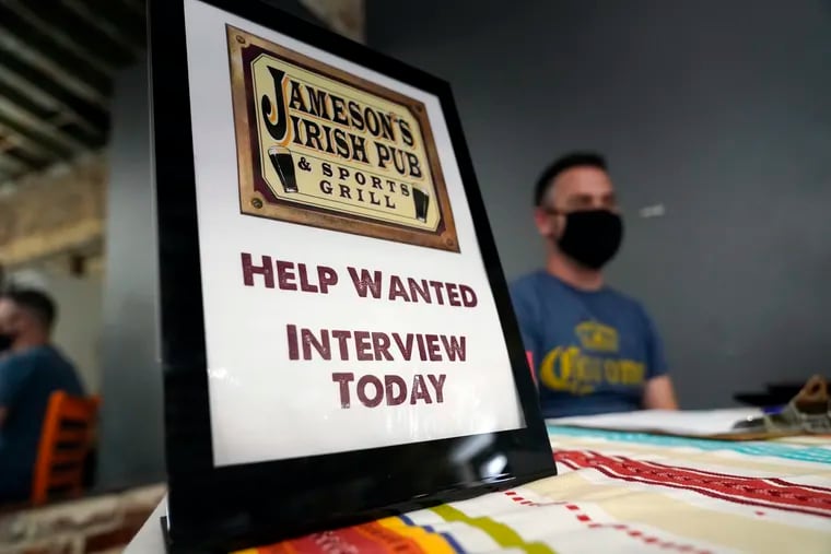 A hiring sign is shown at a booth for Jameson's Irish Pub during a job fair in the West Hollywood section of Los Angeles.