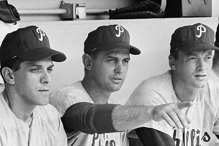 Phillies Manager Gene Mauch, center, and pitcher Jim Bunning, right, are shown in dugout at Shea Stadium as they studied New York batters, June 20, 1964, New York. On June 21, Bunning pitched a perfect game, retiring all 27 batters as the Phillies won 6-0 of the Mets in the first game of a double header. The man on the left is unidentified. (AP Photo)