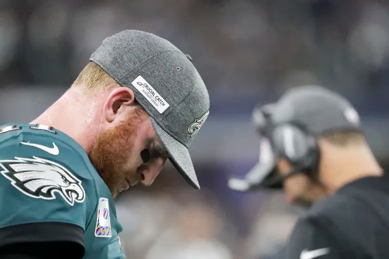 Eagles quarterback Carson Wentz bows his head on the Eagles sidelines during the fourth-quarter against the Dallas Cowboys on Sunday, October 20, 2019 in Arlington, TX.