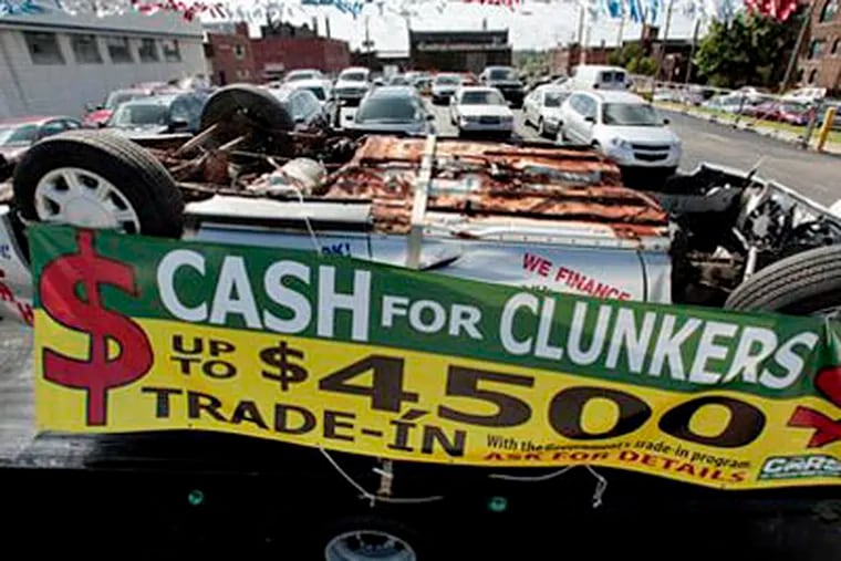 A  Cash for Clunkers sign hangs on a upside down automobile Friday at a dealership in Detroit. The Obama administration will bring to an end the popular $3 billion Cash for Clunkers program on Monday, giving car shoppers a few more days to take advantage of big government incentives. (AP Photo / Paul Sancya)