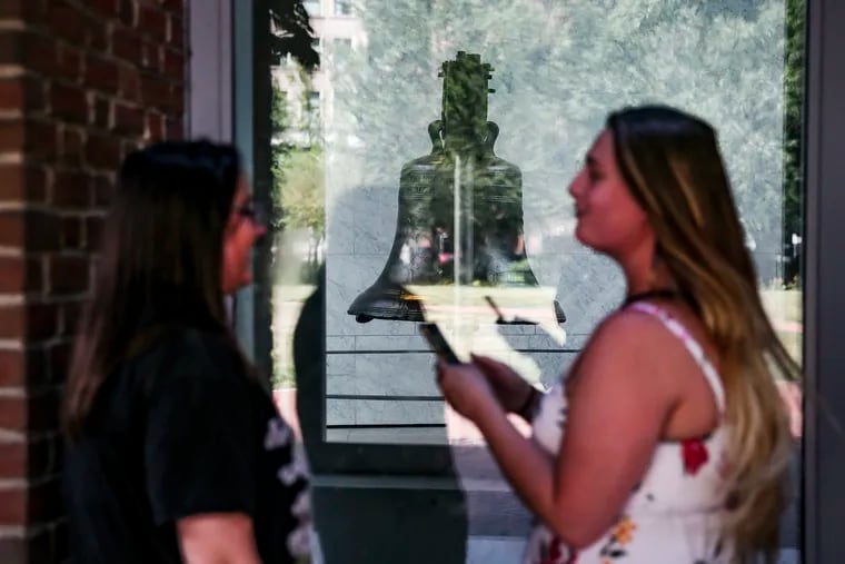 Amanda Schultz, left and Haley Chason both from Philadelphia stop to just poke their heads into the side window to get a glimpse of the Liberty Bell, Monday, June 29, 2020