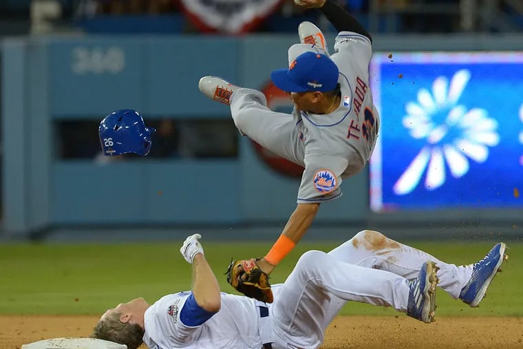 New York Mets shortstop Ruben Tejada (11) collides with Los Angeles Dodgers second baseman Chase Utley (26) at second base during the seventh inning in game two of the NLDS at Dodger Stadium.