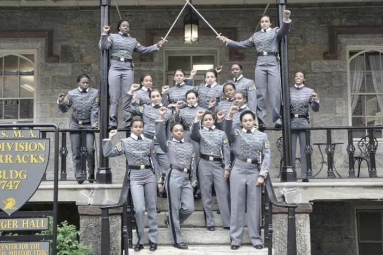 Black female cadets pose in uniform, fists raised, at the U.S. Military Academy at West Point.