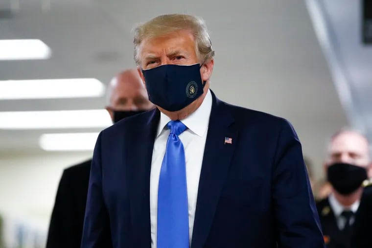 President Donald Trump wears a mask as he walks down the hallway during his visit to Walter Reed National Military Medical Center in Bethesda, Md., Saturday, July 11, 2020.
