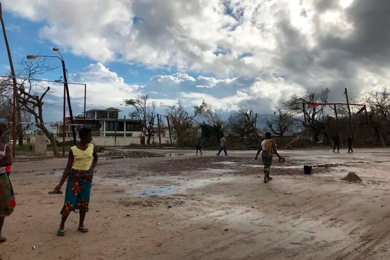 People go on their morning errands amid the shattered city of Beira, Friday, March 22 2019. Some hundreds of people are dead, many more still missing and with many thousands at risk from massive flooding in Mozambique, Malawi and Zimbabwe caused by Cyclone Idai.