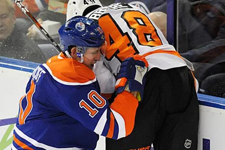 Danny Briere gets checked into the boards by the Oilers' Shawn Horcoff. (John Ulan/The Canadian Press/AP)
