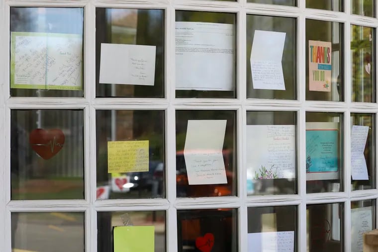 Notes for healthcare workers are taped in the front window at the Kimberly Hall North nursing home in Windsor, Conn., in May. To protect residents, longterm care facilities can't allow visitors, which makes the support offered by staff all the more vital.