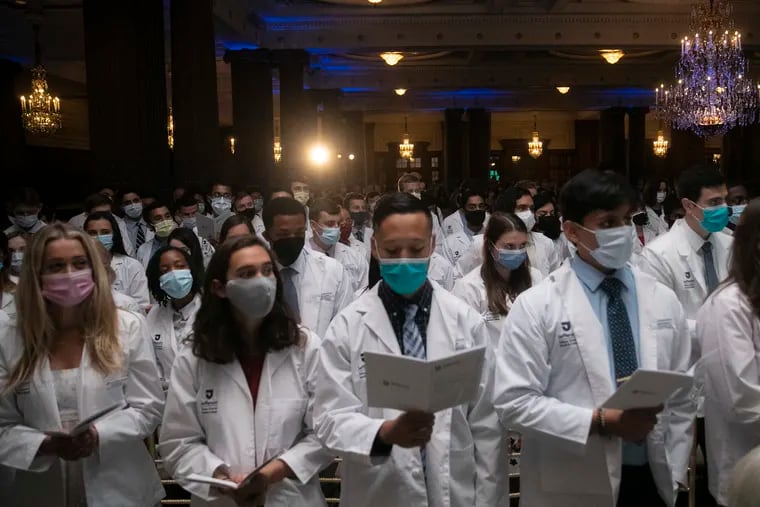 Sidney Kimmel Medical College students read the Hippocratic oath during a white coat ceremony at the Crystal Tea Room inside the Wanamaker Building in Philadelphia. According to a recent report, the U.S. is facing a looming doctor shortage.