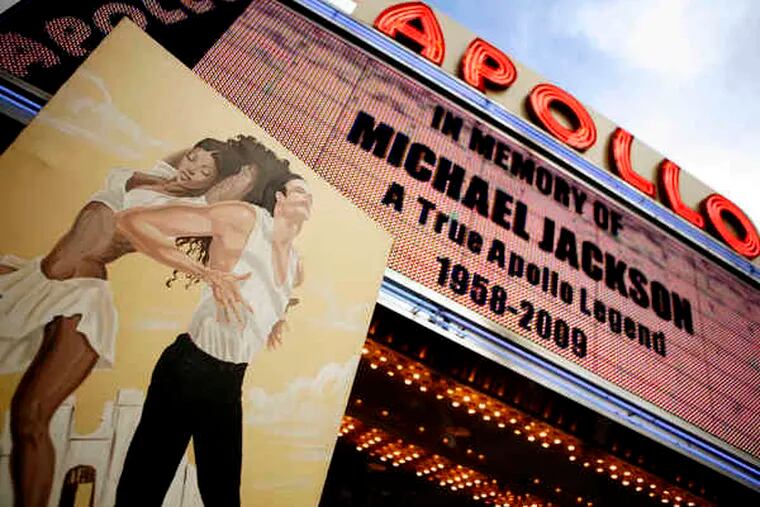 A painting of Michael Jackson was held aloft yesterday outside Harlem's Apollo Theater in New York. A personal cardiologist had been living with Jackson while he rehearsed for a comeback.