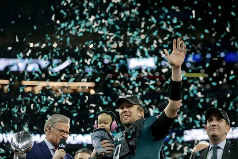 The Eagles' Nick Foles hold his daughter, Lilly, as he celebrates the Eagles' win over the New England Patriots in Super Bowl LII.