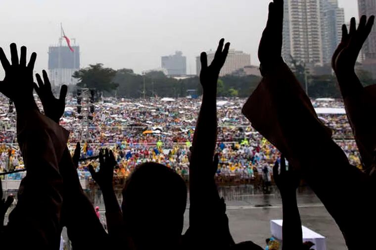 The faithful wave as they wait for the arrival of Pope Francis for a Mass in Manila, Philippines, on Sunday.
