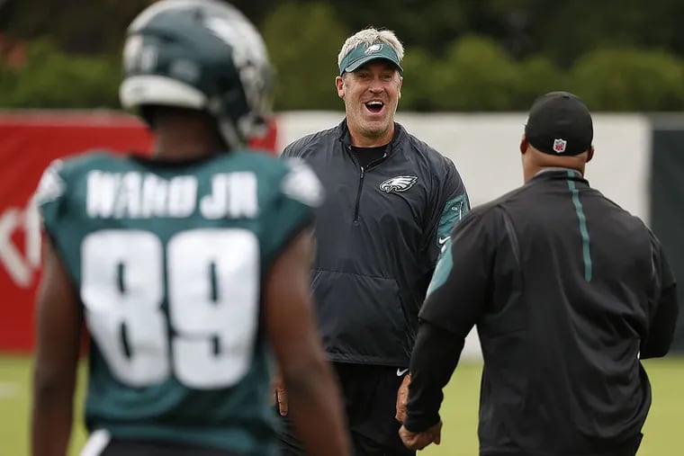 Eagles head coach Doug Pederson (center) talks with running back coach Duce Staley (right) during practice.