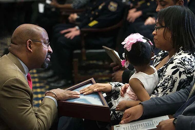 Mayor Nutter presents a flag to Shakira Wilson-Burroughs, sister of slain Sgt. Robert Wilson III, yesterday at a City Hall ceremony to mark the end of the city's 30 days of mourning. ALEJANDRO A. ALVAREZ / STAFF PHOTOGRAPHER