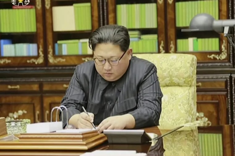 This image made from video of a news bulletin aired by North Korea's KRT on Nov. 29, 2017, shows an image of North Korea's leader Kim Jong Un signing what is said to be a document on Nov. 28, 2017, authorizing a missile test.