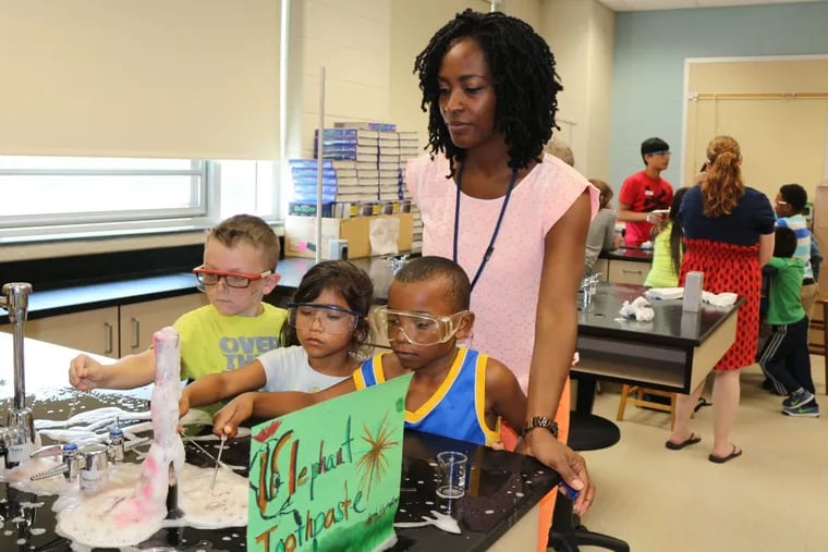 Pennsauken elementary students (l-r) Logan Mayberry, 6, Maryel Torres, 5 and Javon McNatt, watch a toothpaste science experiment as Principal Tanya Harmon watches. They are participating in free summer enrichment classes offered by the district.