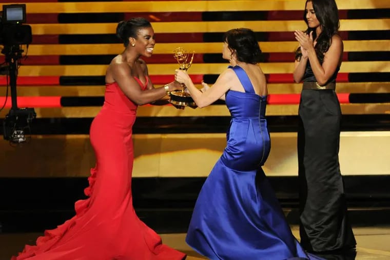 Uzo Aduba, left, presents the award for outstanding directing for a comedy series to Gail Mancuso for her work on â€œModern Familyâ€� at the 66th Annual Primetime Emmy Awards at the Nokia Theatre L.A. Live on Monday, Aug. 25, 2014, in Los Angeles. (Photo by Chris Pizzello/Invision/AP)