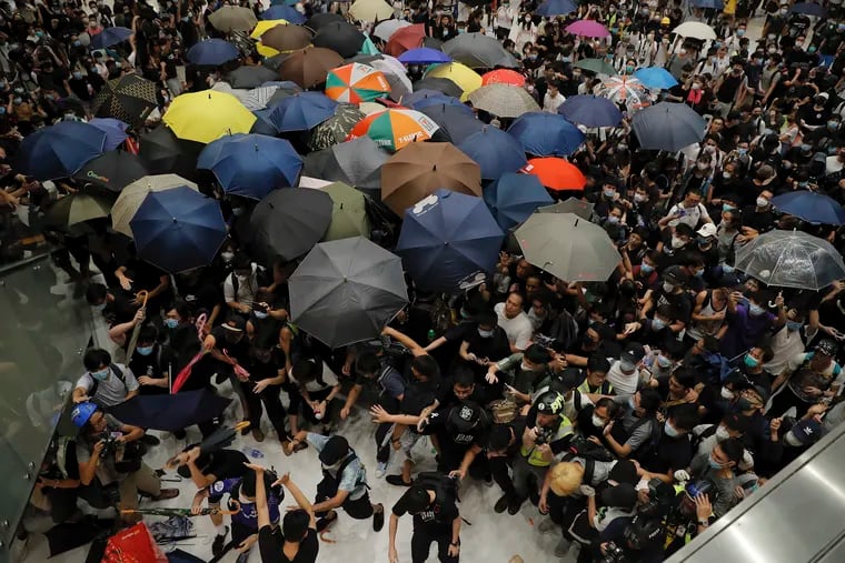 Protesters scuffle with policemen inside a shopping mall in Sha Tin District in Hong Kong, Sunday, July 14, 2019. Police in Hong Kong have fought with protesters as they broke up a demonstration by thousands of people demanding the resignation of the Chinese territory's chief executive and an investigation into complains of police violence. (AP Photo/Kin Cheung)