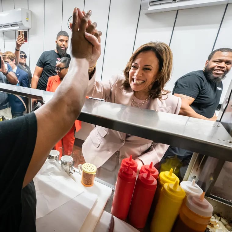 Genevia Ware (left), from Jim’s West Steaks and Hoagies, and Vice President Kamala Harris (right), high five at the shop in West Philadelphia. The Vice President went to Jim’s West after giving the keynote speech at the SEIU convention.