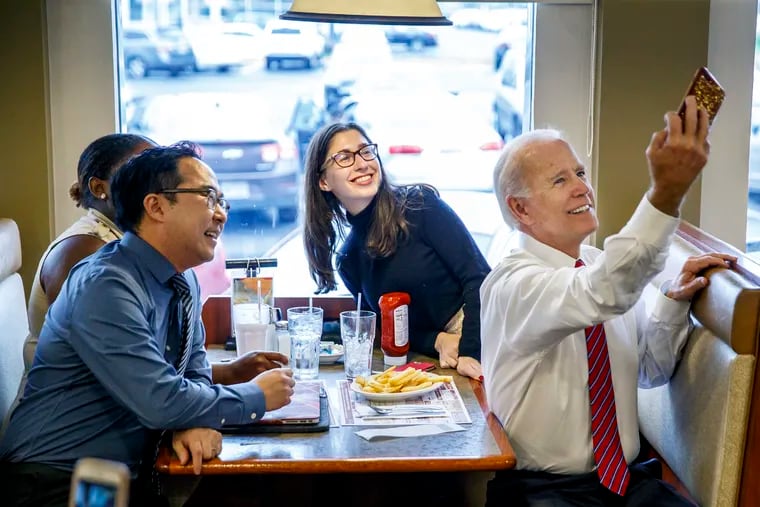 Former vice president Joe Biden, right, takes a selfie with Democratic candidate Andy Kim, left, and diners at the Golden Dawn Diner in Willingboro , NJ on October 15, 2018.