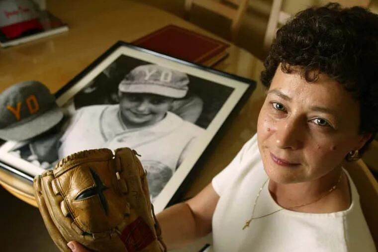 Maria Pepe poses with the glove she used to play Little League baseball with in her Hoboken, N.J., apartment. In the background a photo of her in her uniform can be seen next to her Young Democrats team hat. Pepe only got to play three Little League games for the Young Democrats of Hoboken back in 1972, but it was the lawsuit brought in her name, and decided 30 years ago Friday, that opened Little League to millions of little girls everywhere. (AP Photo/Christopher Barth)