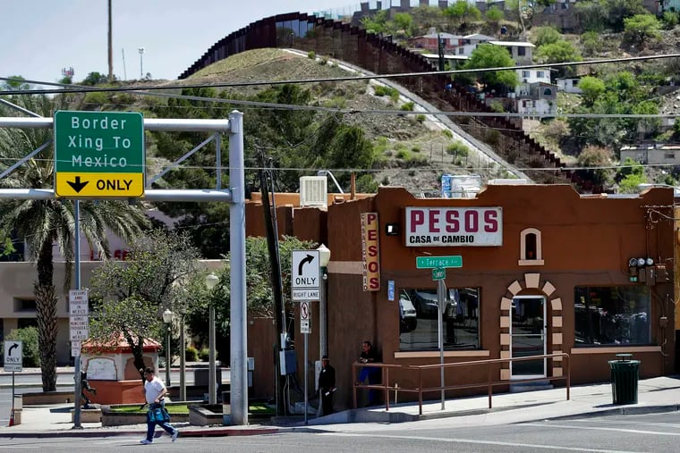 FILE - In this April 10, 2018, file photo, the International border cuts through Nogales, Sonora, Mexico, rear, as seen from Nogales, Ariz. Federal court records say a Border Patrol agent in Arizona sent texts referring to migrants as "savages" and "subhuman" the month before allegedly knocking over a Guatemalan man with his patrol vehicle. The filings in U.S. District Court in Tucson earlier in May 2019 say Agent Matthew Bowen sent the text messages in November 2017, weeks before allegedly knocking down the migrant. He goes on trial Aug. 13. He has pleaded not guilty to depriving the migrant of his rights and falsifying records. (AP Photo/Matt York, File)