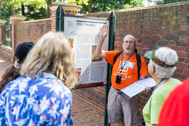 Jerry Silverman, a volunteer tour guide with the Preservation Alliance for Greater Philadelphia, leads a group through Queen Village starting at the Gloria Dei Church.