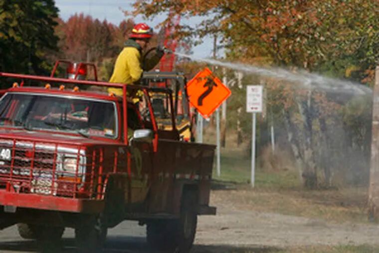 The fire in Wharton State Forest had spread over 1,800 acres in Burlington, Camden and Atlantic Counties. Here, state crews fight hot spots along Route 206.