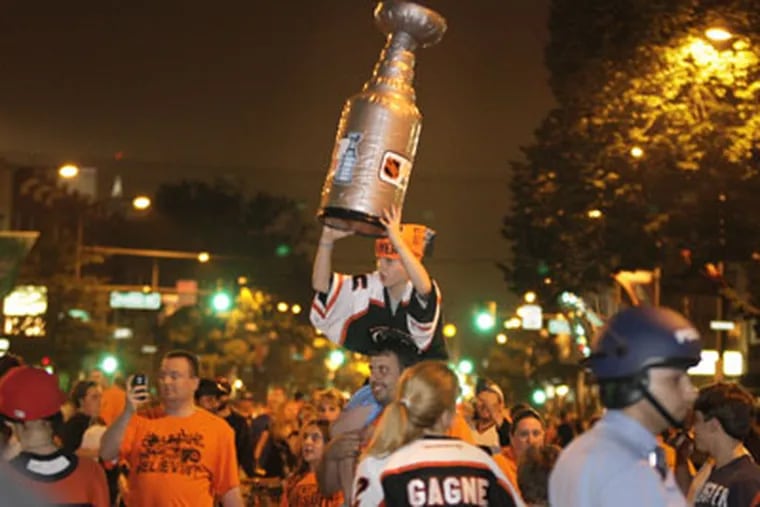 Josh Mac Donald of Phila.  holds son Jacob,8, and the Stanley Cup on
Broad St. near Shunk after the Phila. Flyers vs. Montreal Canadiens
game on May 24, 2010. ( Elizabeth Robertson / Staff Photographer )