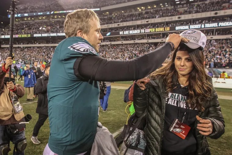 Eagles quarterback Nick Foles, left, puts a Conference Champion hat on the head of his wife, Tori Moore, right, during the celebration after the Eagles beat the Vikings in the NFC Championship game.