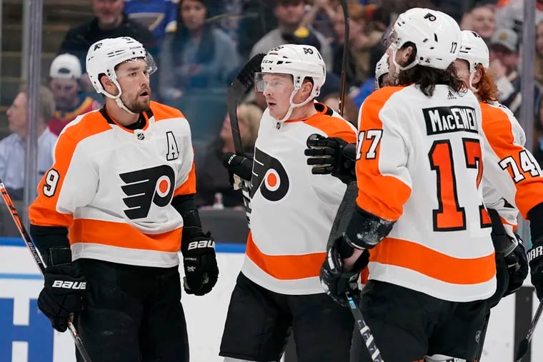 Philadelphia Flyers' Patrick Brown, center, is congratulated by teammates Ivan Provorov (9) and Zack MacEwen (17) after scoring during the first period of an NHL hockey game against the St. Louis Blues Thursday, March 24, 2022, in St. Louis. (AP Photo/Jeff Roberson)