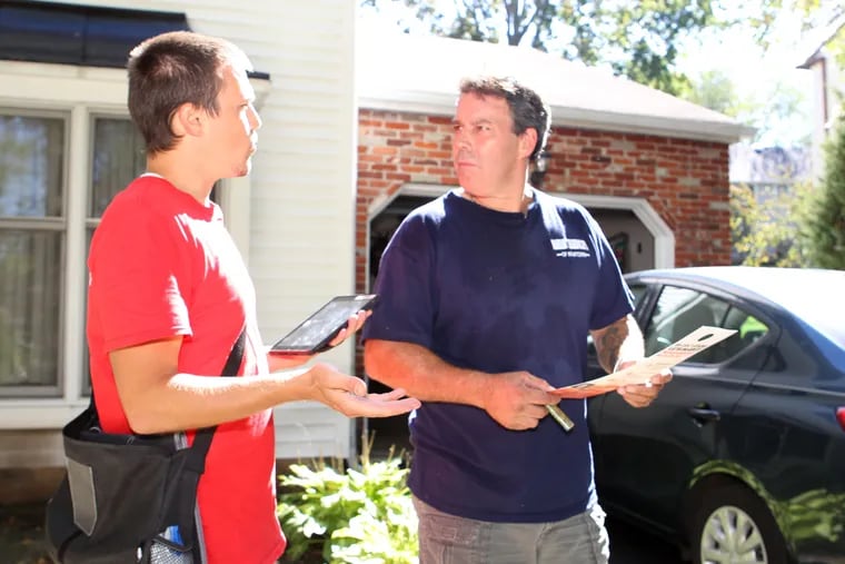 Americans for Prosperity staffer Chris Saterstad (left) works to convince Bucks County resident Eric Oelschlegel to oppose Democrat Katie McGinty for Senate in 2016. (BEVERLY SCHAEFER/ For the Inquirer)