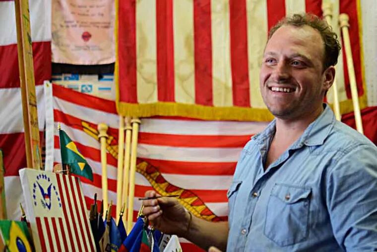 Busy with constant costumers since the World Cup started, Matt O’Connor has been working full time at his family business, Humphrys Flag Co. on Arch Street since 2004, but the store has been running in Philadelphia since 1864. (VIVIANA PERNOT/Staff Photographer)